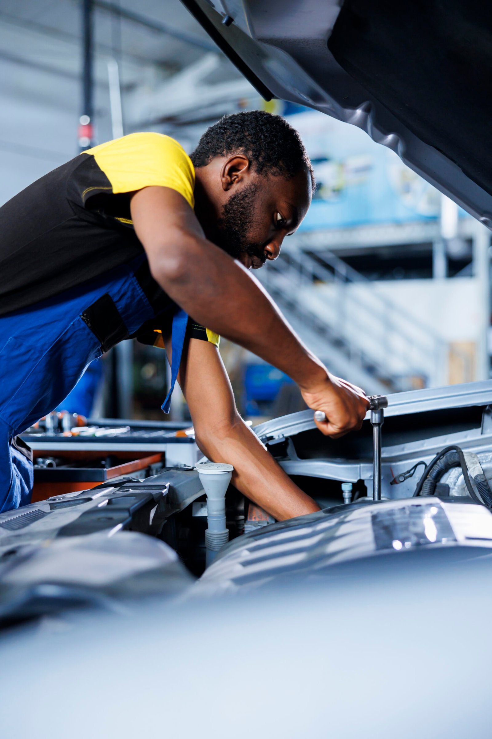 mechanic fixes car fuel tank in garage